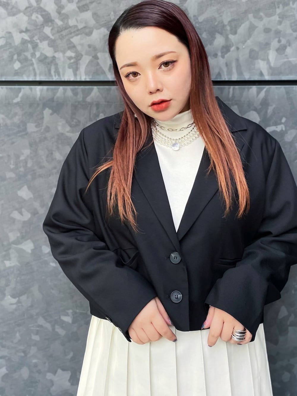 ブラック系のテーラードジャケット、ホワイト系のスカート、ホワイト系のTシャツ/カットソーを着用したレディースの冬コーディネートの3枚目の写真