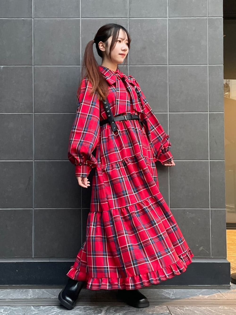 レッド系のワンピース、ブラック系のベルトを着用したレディースの秋コーディネートの3枚目の写真