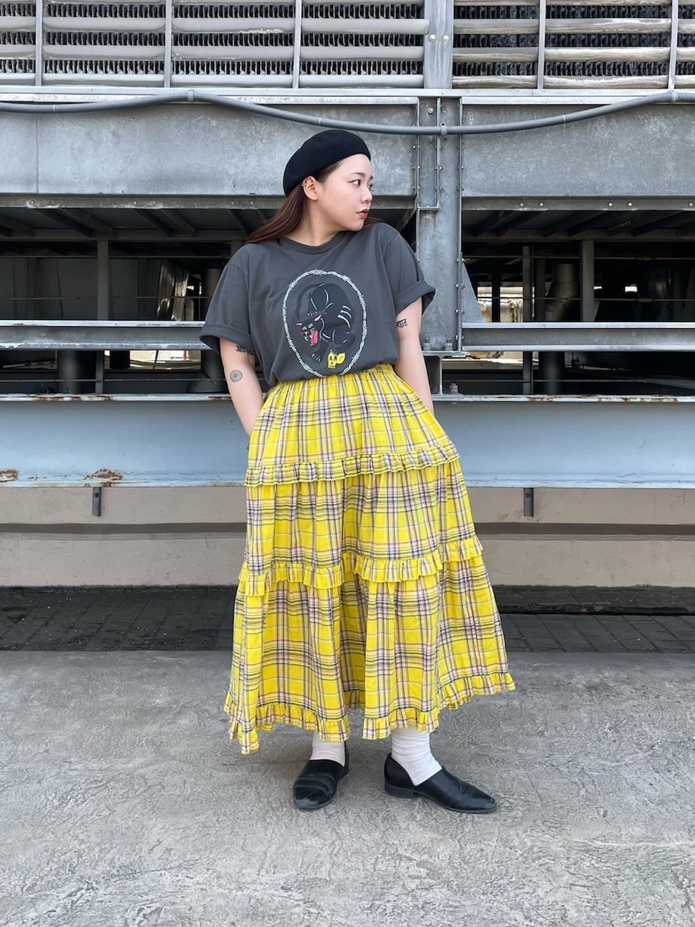 ブラック系のTシャツ/カットソー、イエロー系のスカートを着用したレディースの夏コーディネートの2枚目の写真