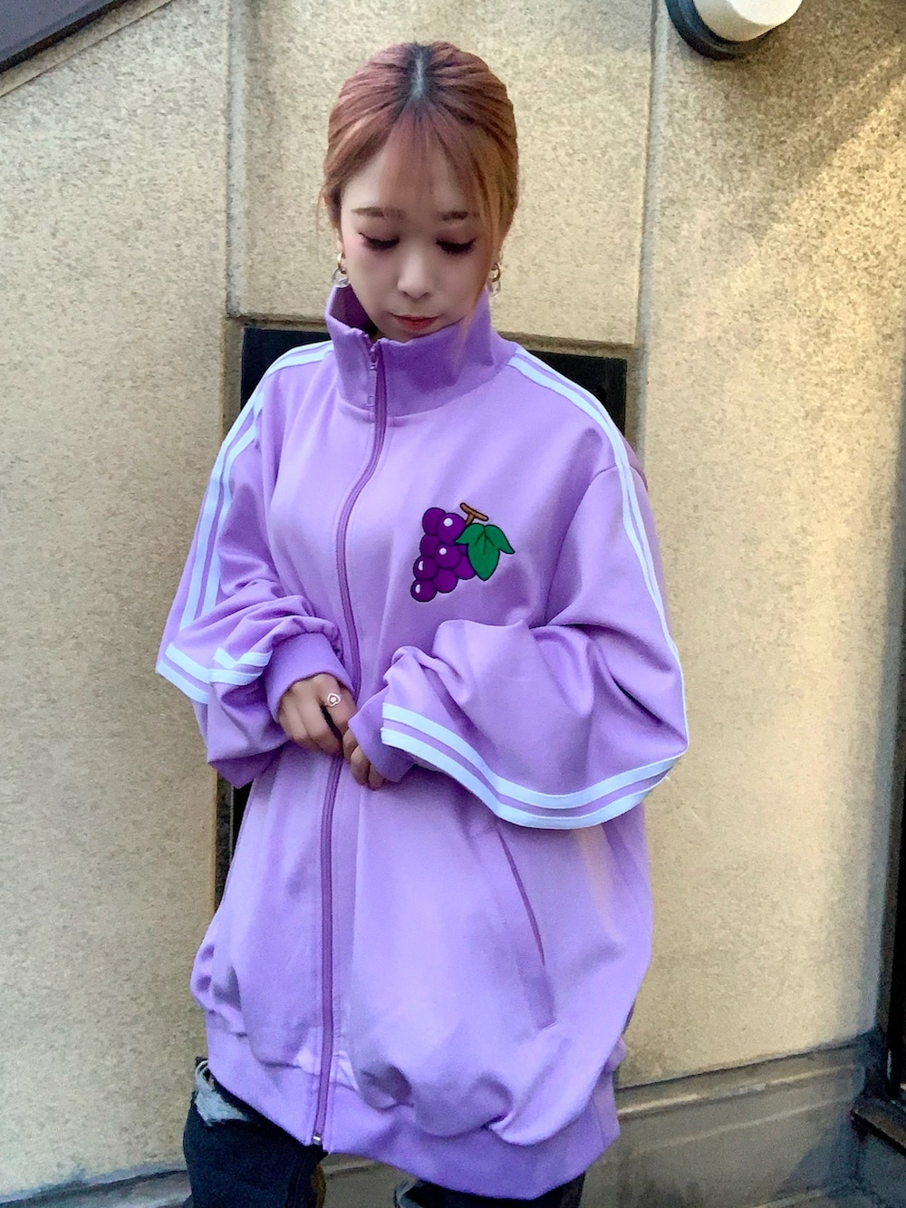 パープル系のジャージ、ブラック系のデニムパンツ、ブラック系のブーツを着用したレディースの冬コーディネートの2枚目の写真