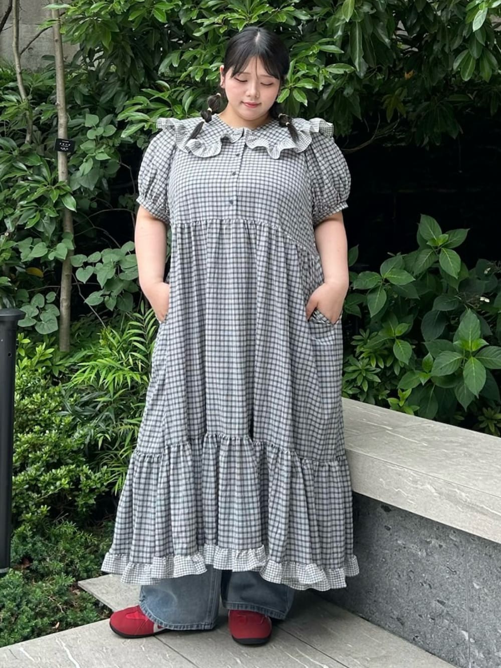 ブラック系のワンピース、ブルー系のデニムパンツを着用したレディースの夏コーディネートの2枚目の写真