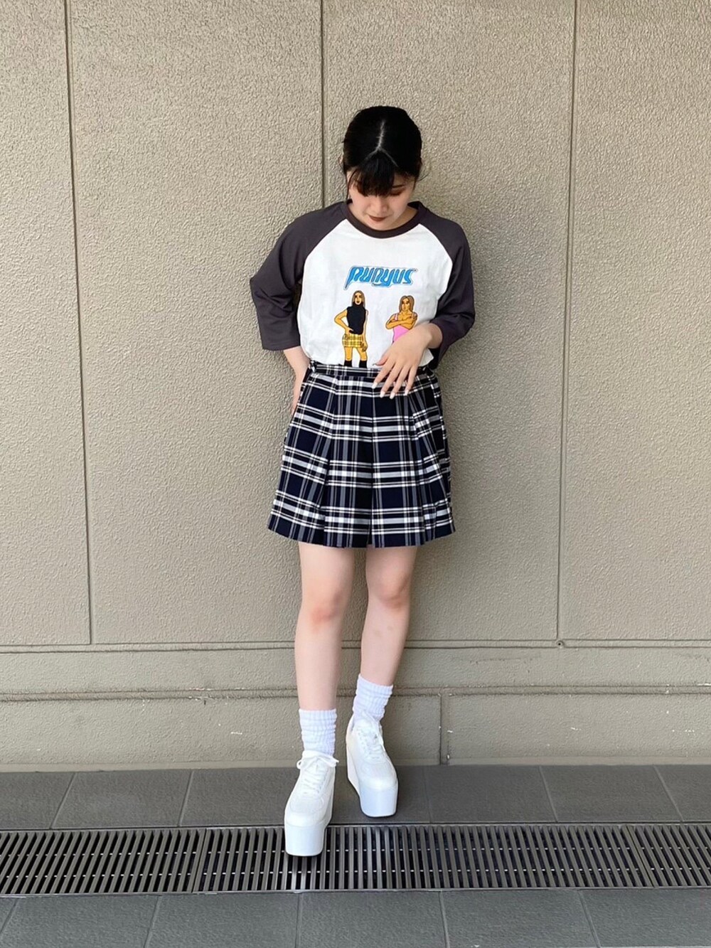 ホワイト系のスニーカー、ブラック系のスカート、ホワイト系のTシャツ/カットソーを着用したレディースの夏コーディネートの2枚目の写真