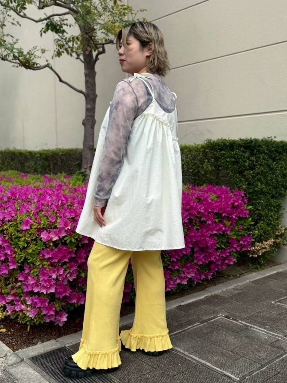 イエロー系のその他パンツ、ホワイト系のワンピース、グレー系のTシャツ/カットソーを着用したレディースの春コーディネートの3枚目の写真