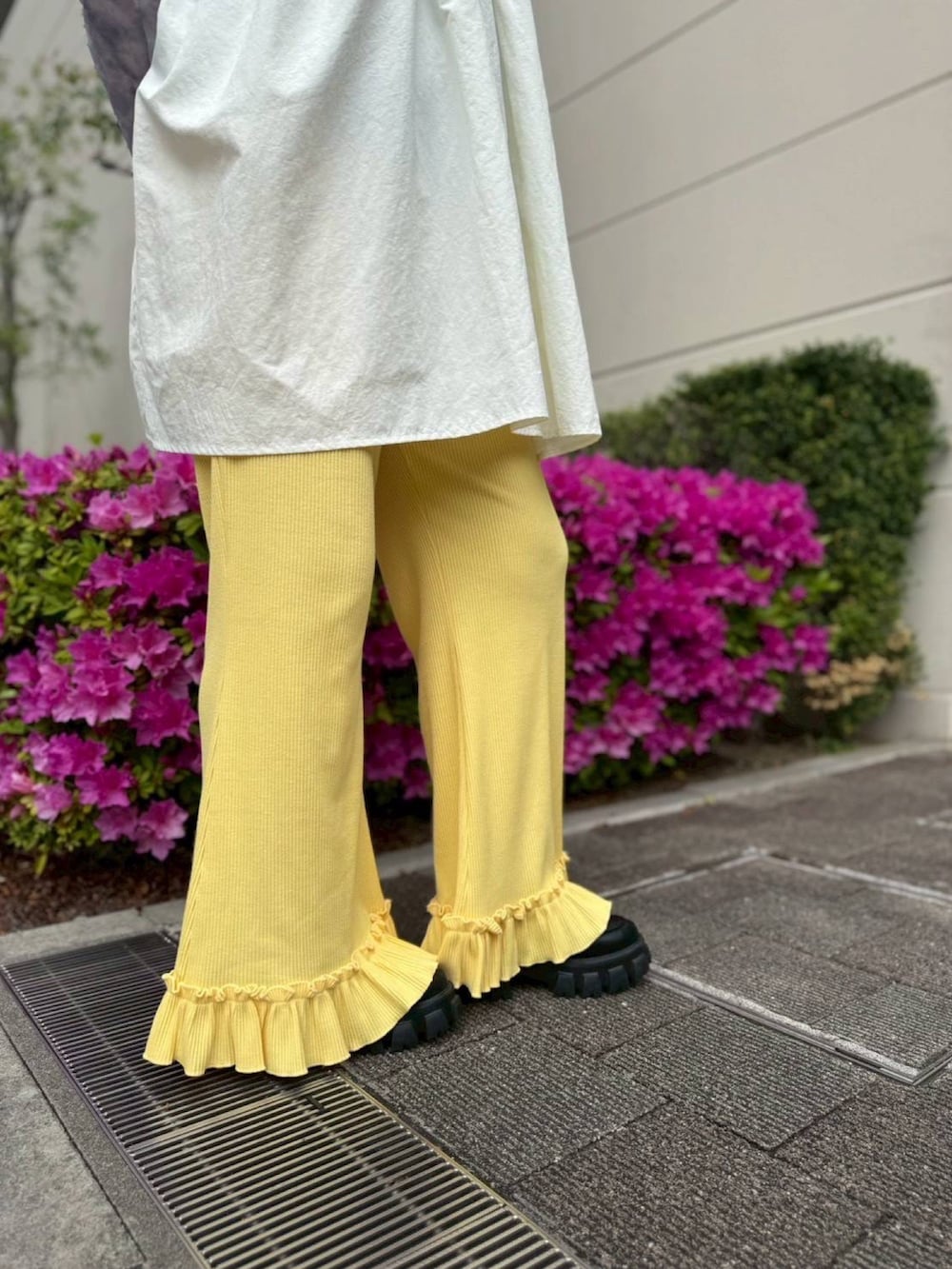 イエロー系のその他パンツ、ホワイト系のワンピース、グレー系のTシャツ/カットソーを着用したレディースの春コーディネートの4枚目の写真