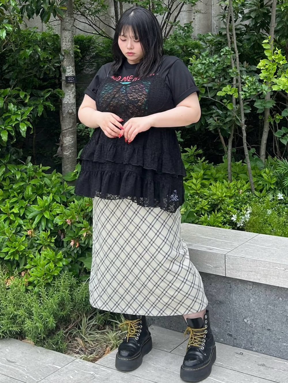 ベージュ系のスカート、ブラック系のワンピース、ブラック系のTシャツ/カットソーを着用したレディースの春コーディネートの3枚目の写真
