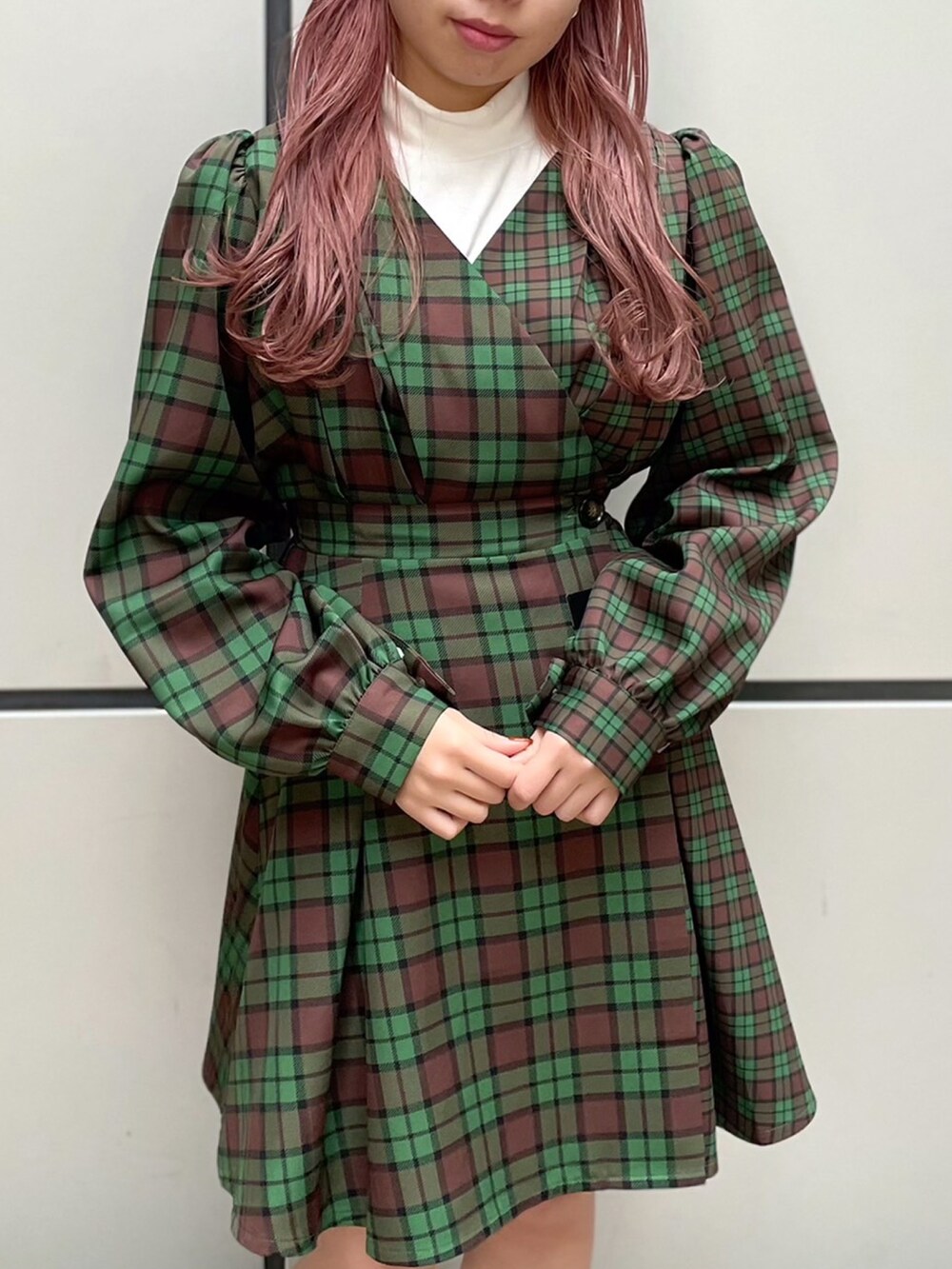 グリーン系のワンピース、ブラック系のライダースジャケット、ホワイト系のニット/セーターを着用したレディースの秋コーディネートの3枚目の写真