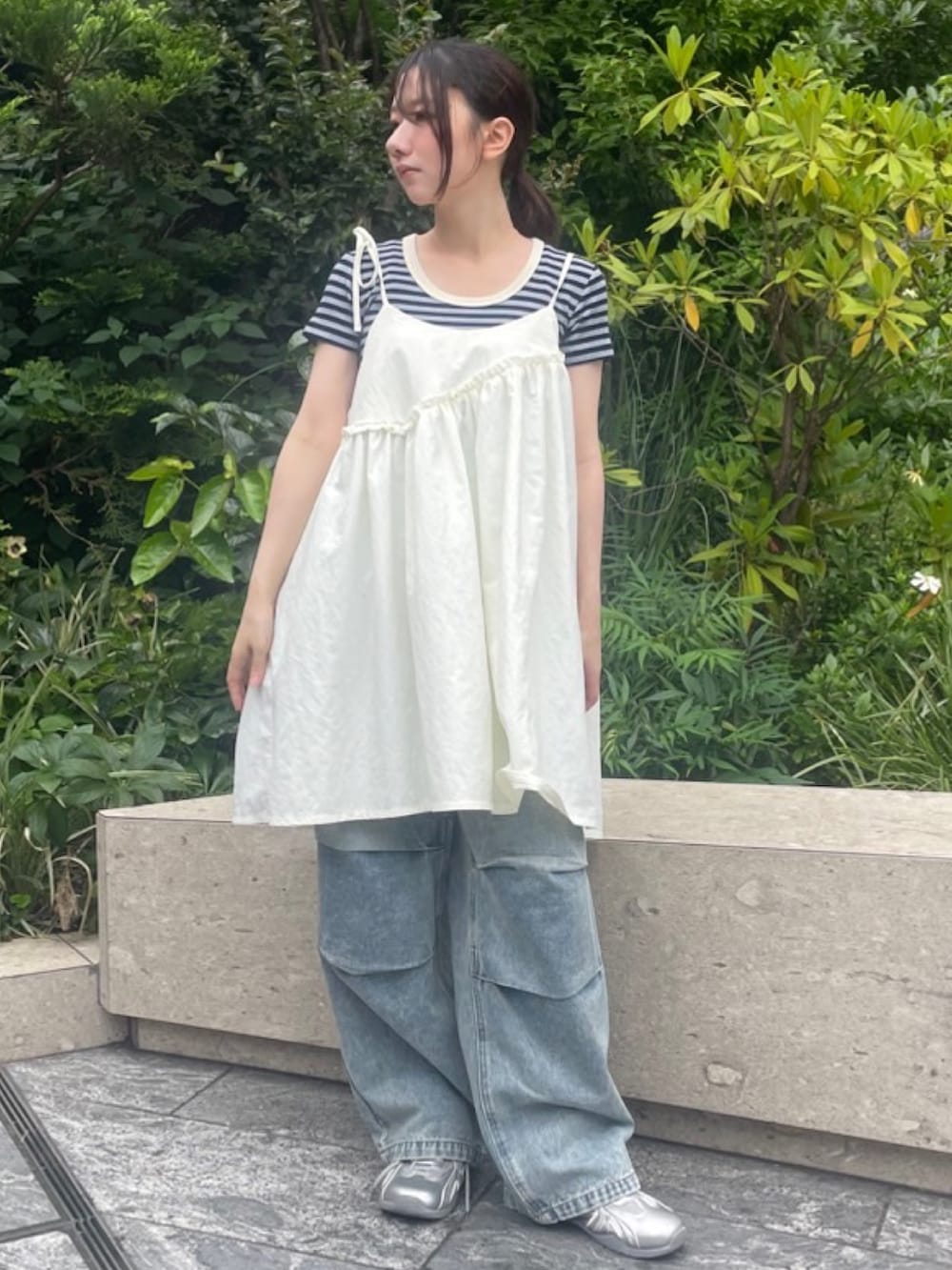 ブルー系のデニムパンツ、ホワイト系のワンピース、ブルー系のTシャツ/カットソーを着用したレディースの夏コーディネートの4枚目の写真