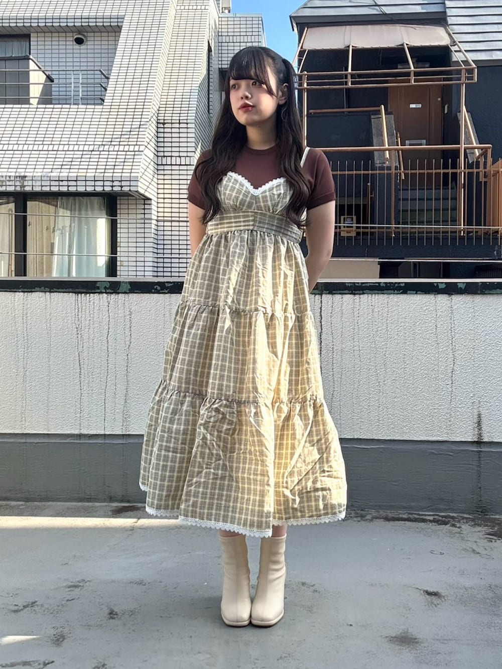 イエロー系のワンピース、ブラウン系のニット/セーターを着用したレディースの夏コーディネートの4枚目の写真