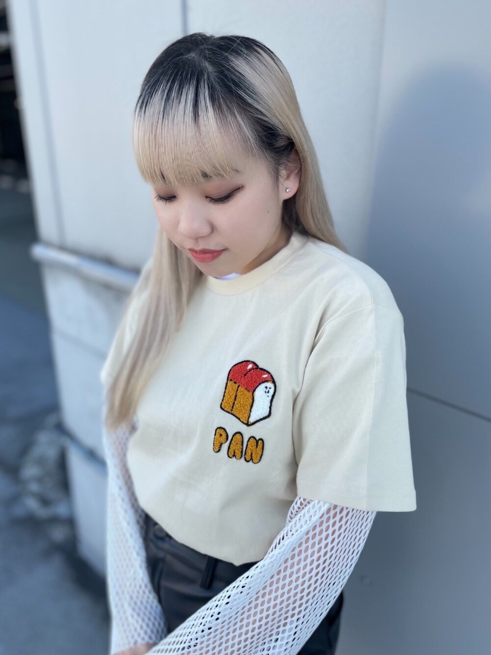 ベージュ系のTシャツ/カットソー、ブラック系のスカート、ホワイト系のTシャツ/カットソーを着用したレディースの春コーディネートの2枚目の写真
