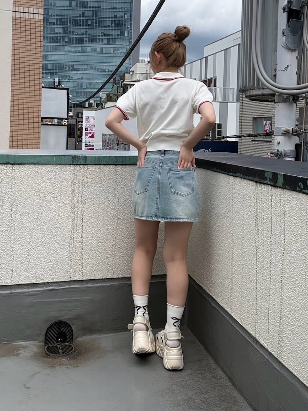 ホワイト系のポロシャツ、ブルー系のデニムスカートを着用したレディースの夏コーディネートの6枚目の写真