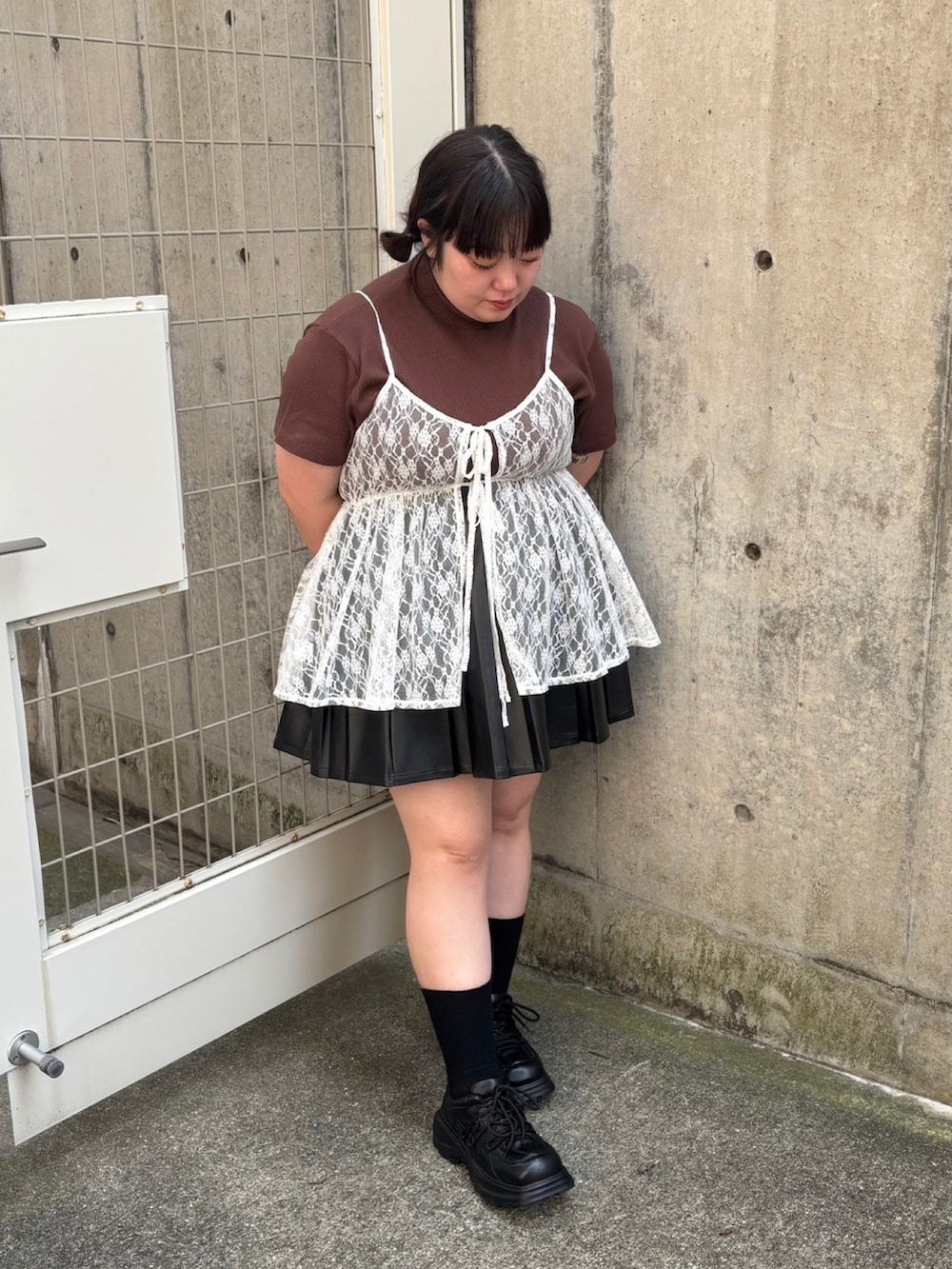 ホワイト系のキャミソール、ブラウン系のTシャツ/カットソー、ブラック系のスカートを着用したレディースの夏コーディネートの2枚目の写真