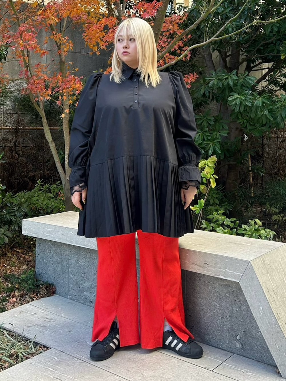 ブラック系のシャツワンピース、レッド系のその他パンツを着用したレディースの冬コーディネートの3枚目の写真