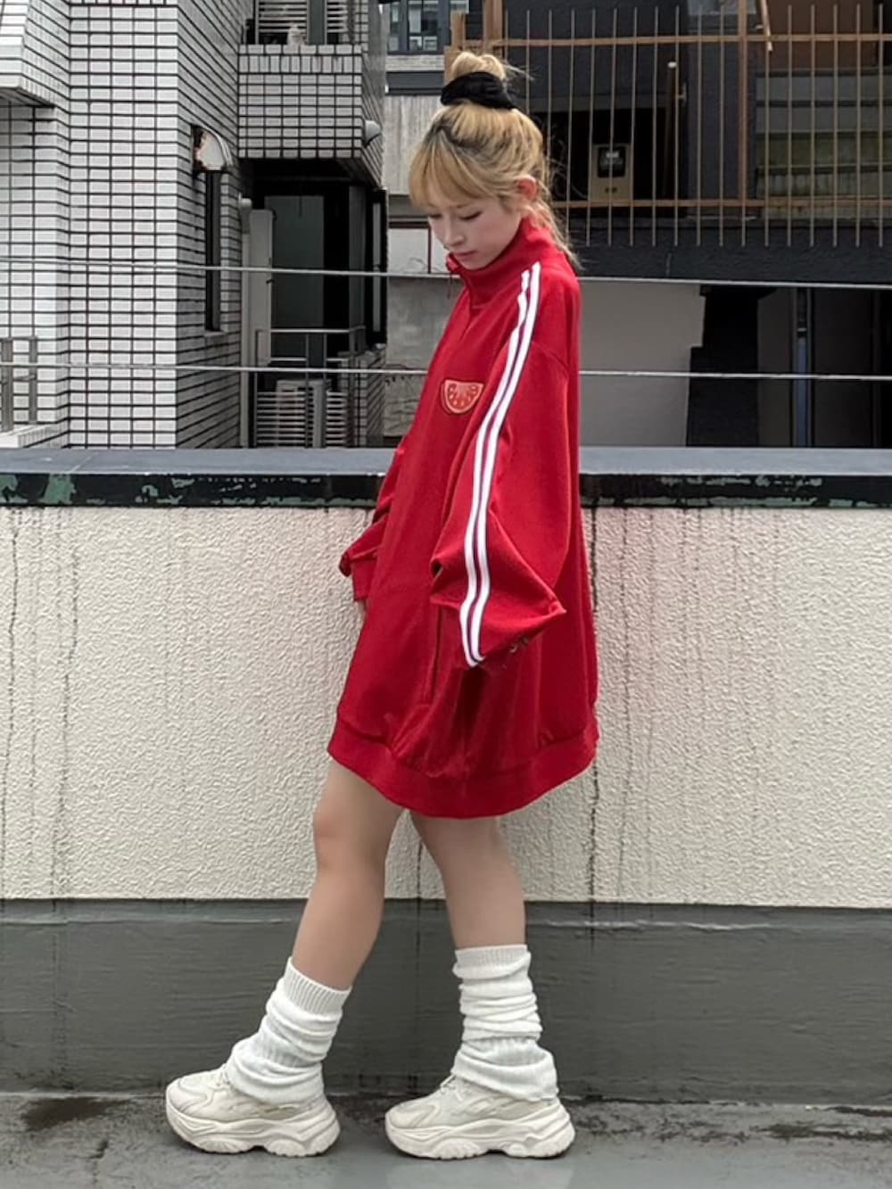 レッド系のジャージを着用したレディースの秋コーディネートの3枚目の写真