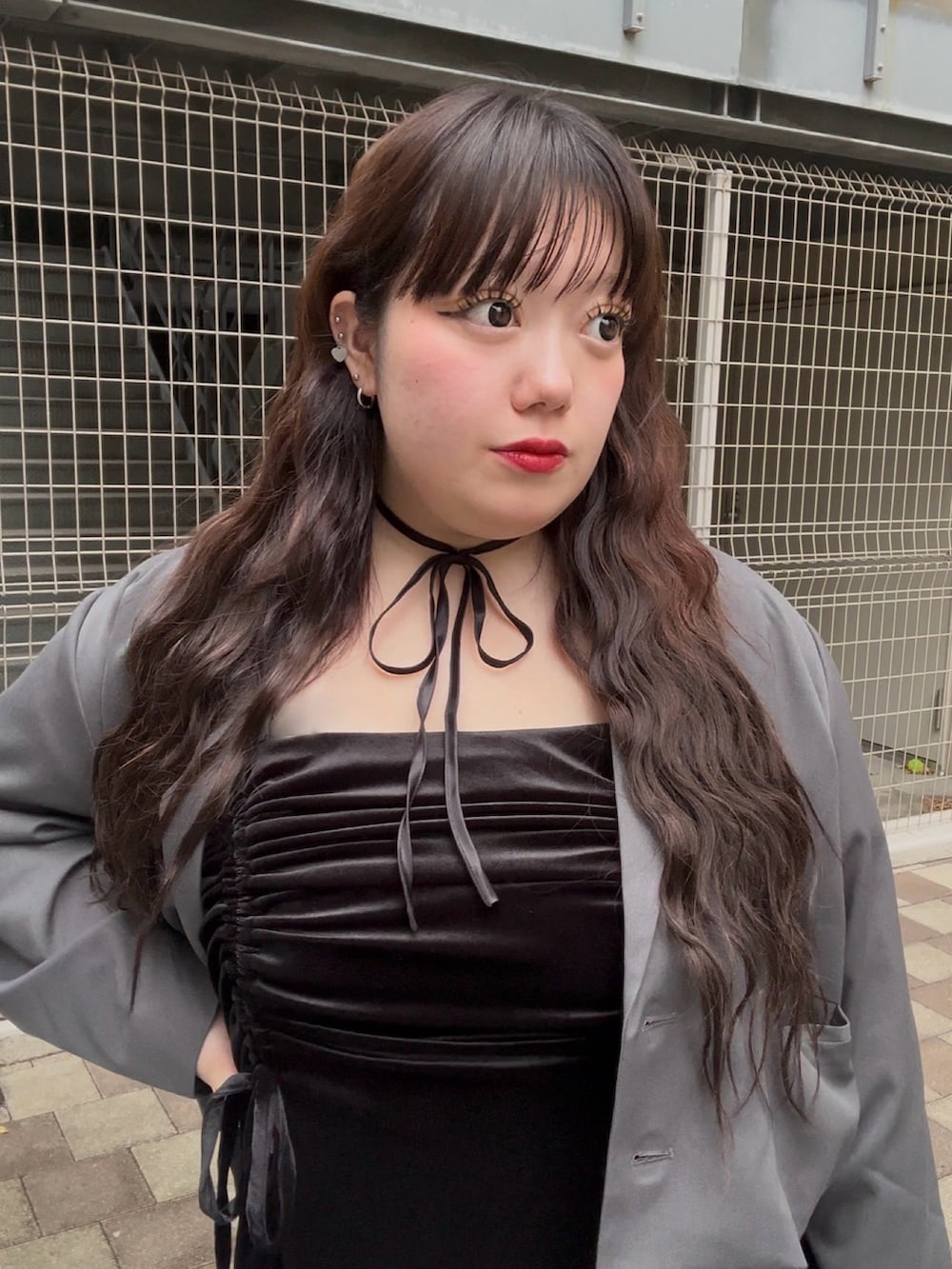 ブラック系のワンピース、グレー系のテーラードジャケットを着用したレディースの春コーディネートの4枚目の写真