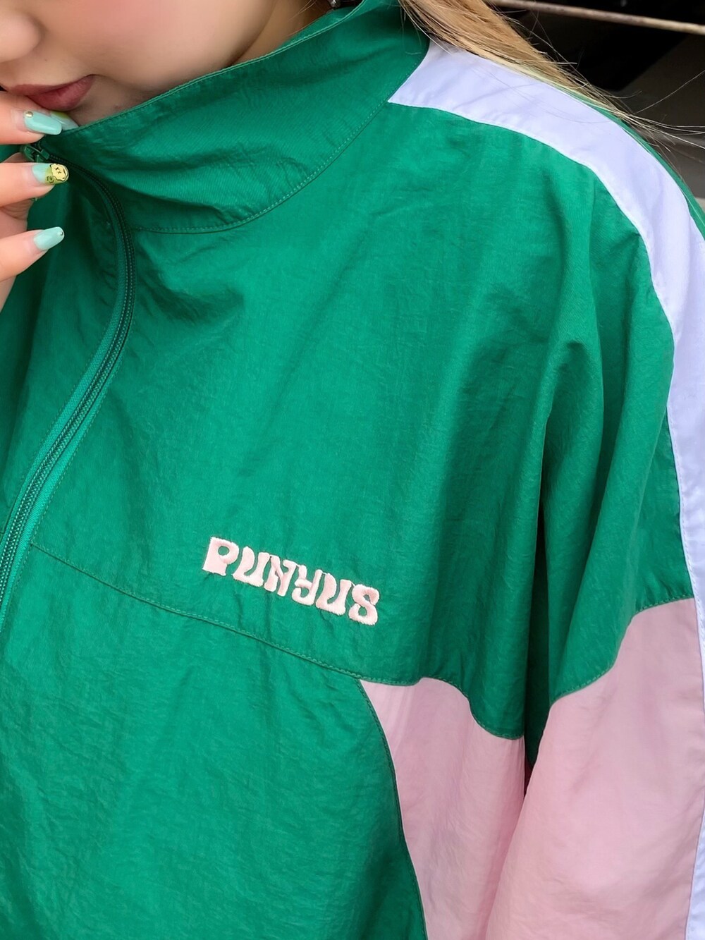 グリーン系のナイロンジャケット、ブルー系のデニムパンツを着用したレディースの冬コーディネートの2枚目の写真