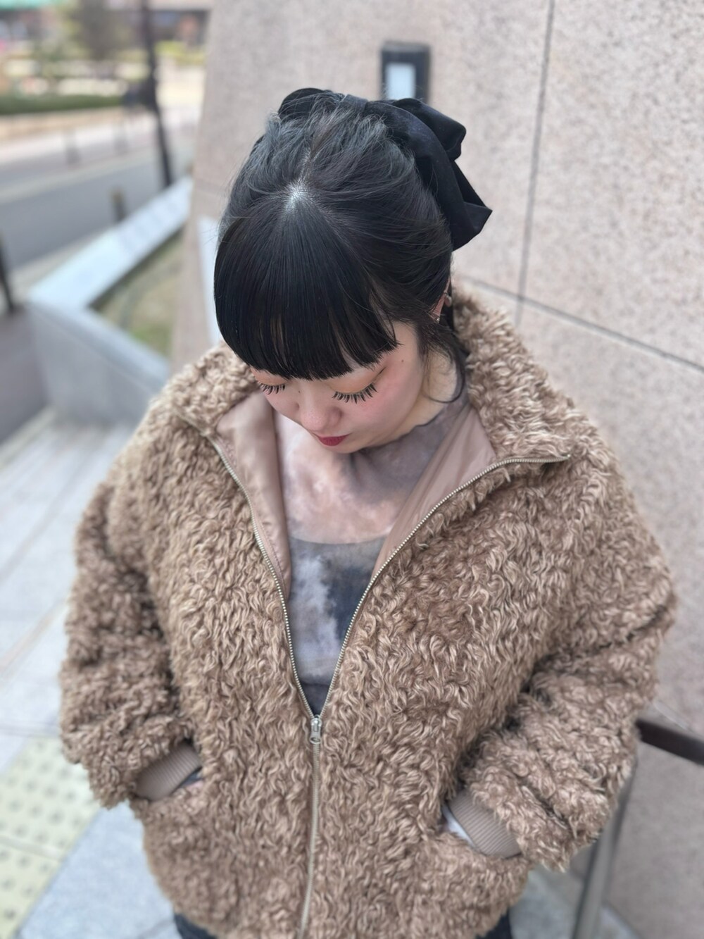 ブラック系のデニムパンツ、ブラック系のデニムスカート、ブラウン系のブルゾンを着用したレディースの冬コーディネートの4枚目の写真