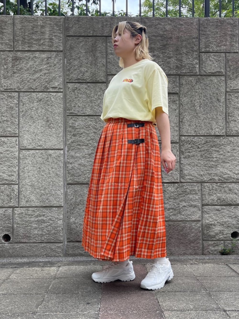 オレンジ系のスカート、イエロー系のTシャツ/カットソーを着用したレディースの夏コーディネートの5枚目の写真