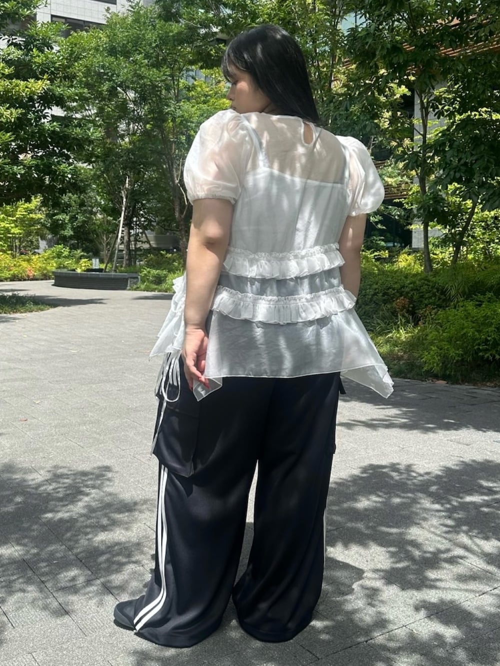 ブラック系のカーゴパンツ、ホワイト系のワンピース、ホワイト系のキャミソールを着用したレディースの夏コーディネートの4枚目の写真