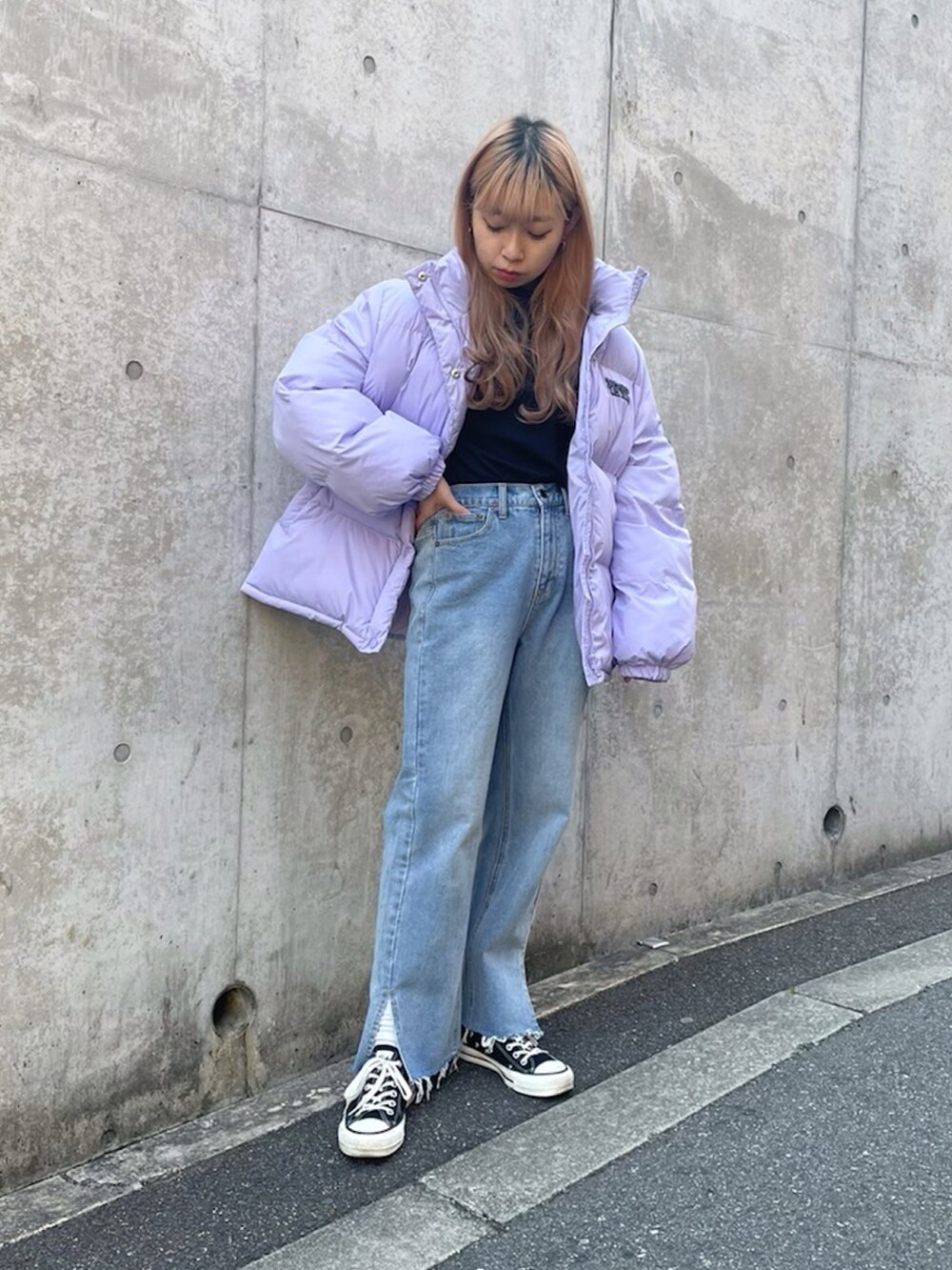 ブルー系のデニムパンツ、パープル系のダウンジャケット/コート、ブラック系のTシャツ/カットソーを着用したレディースの冬コーディネートの2枚目の写真