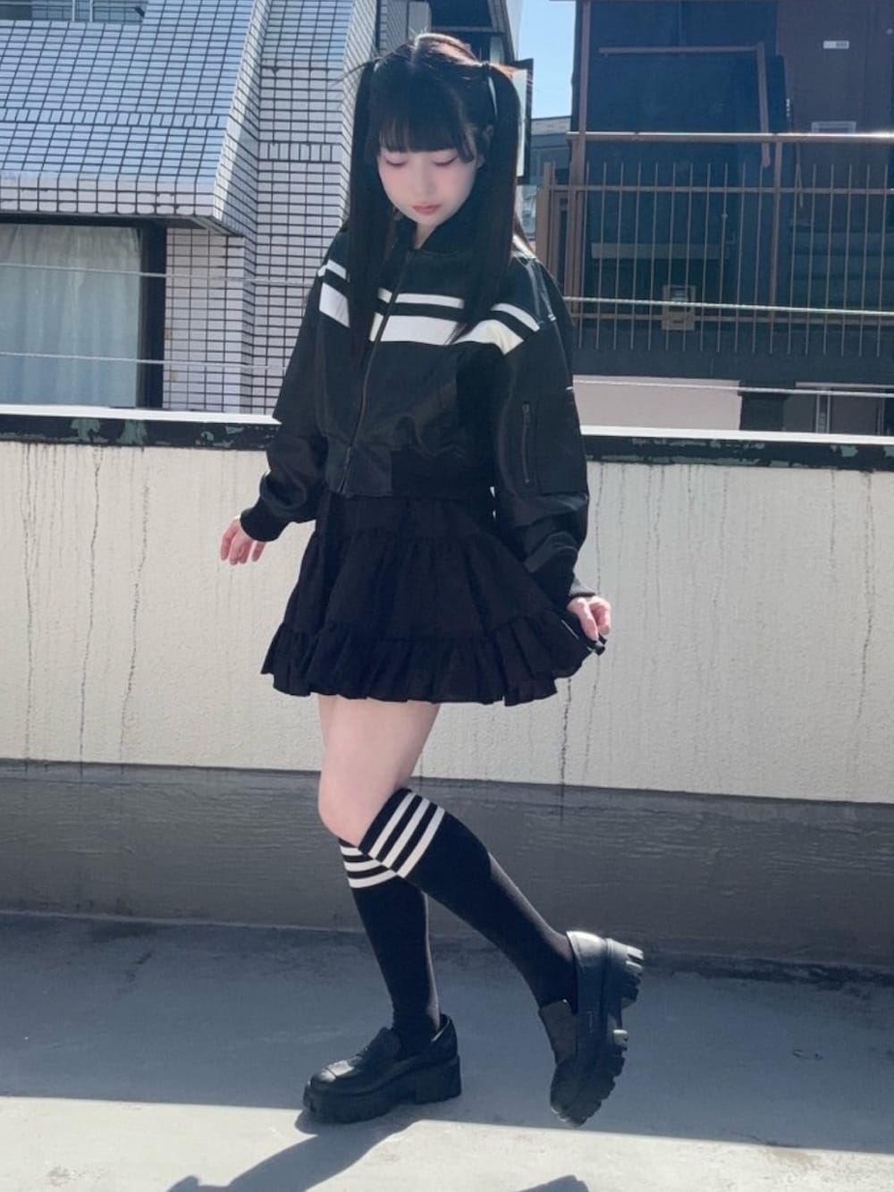 ブラック系のスカート、ブラック系のブルゾンを着用したレディースの春コーディネートの3枚目の写真