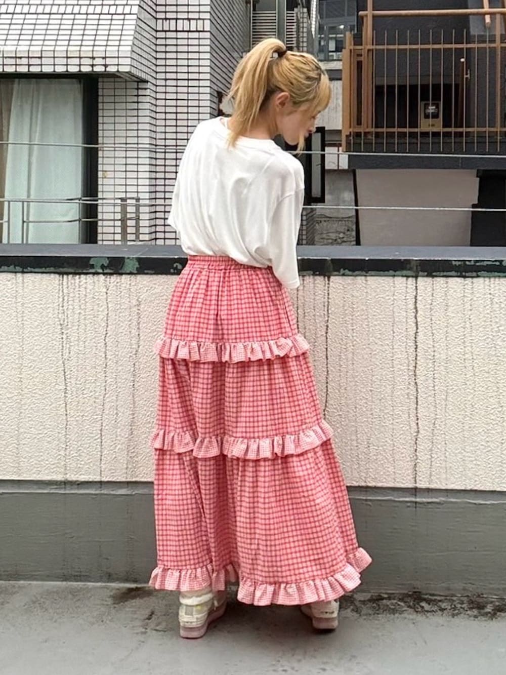 レッド系のスカート、ホワイト系のTシャツ/カットソーを着用したレディースの夏コーディネートの4枚目の写真