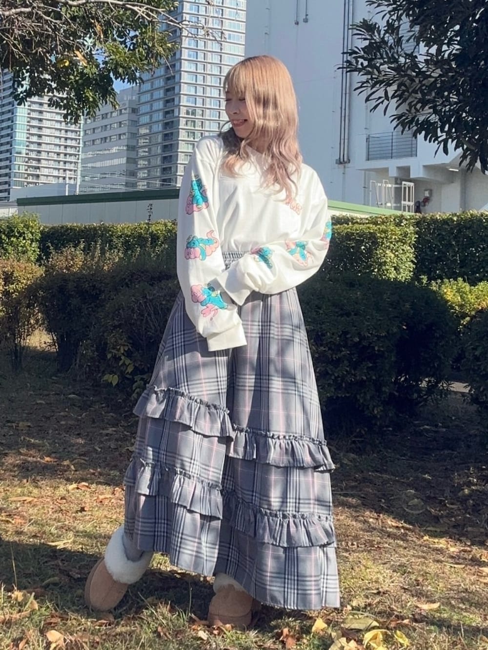 グレー系のスカート、ホワイト系のTシャツ/カットソー、ピンク系のニット/セーターを着用したレディースの秋コーディネートの5枚目の写真