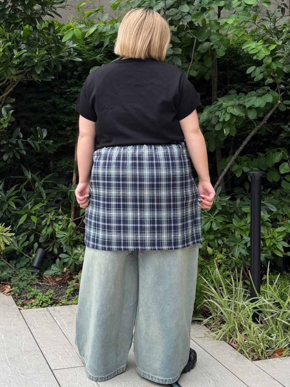 ブルー系のデニムパンツ、ブルー系のスカート、ブラック系のニット/セーターを着用したレディースの夏コーディネートの3枚目の写真