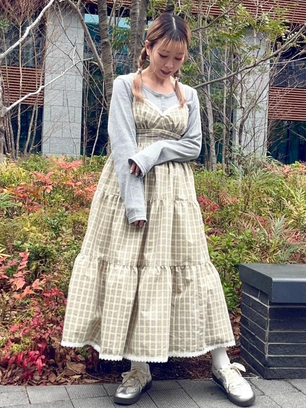 イエロー系のワンピース、グレー系のカーディガン/ボレロを着用したレディースの冬コーディネートの2枚目の写真