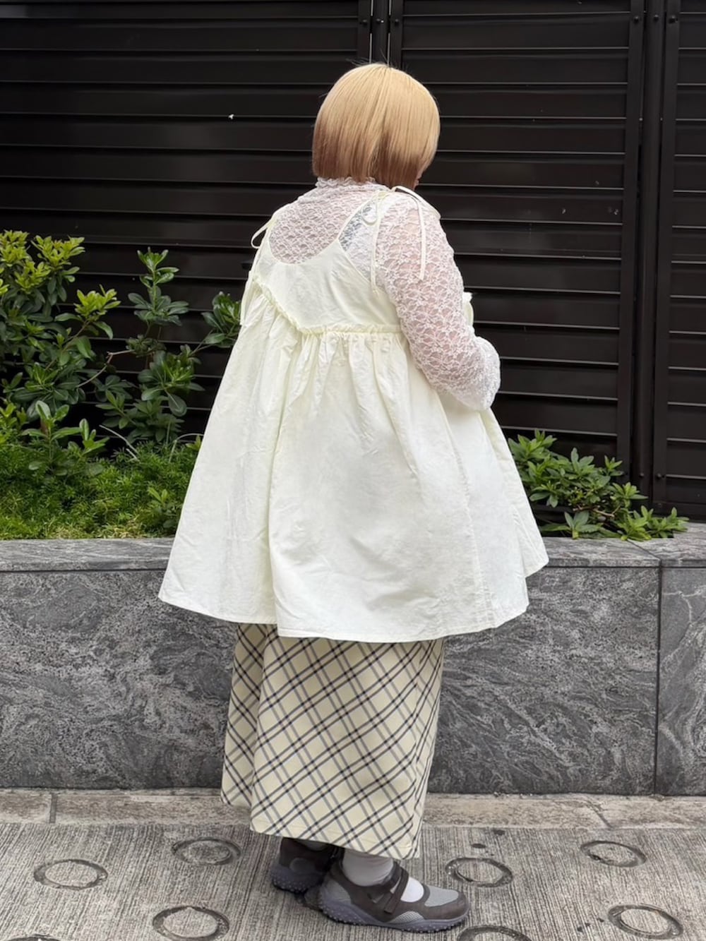 ベージュ系のスカート、ホワイト系のワンピース、ホワイト系のTシャツ/カットソーを着用したレディースの夏コーディネートの3枚目の写真