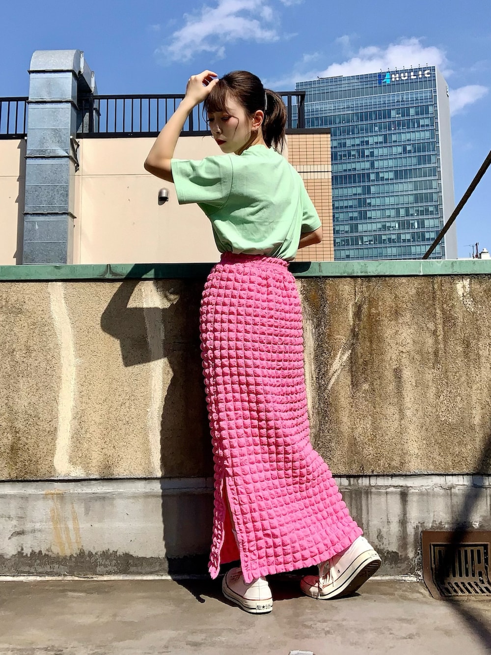 ピンク系のスカート、グリーン系のTシャツ/カットソーを着用したレディースの春コーディネートの3枚目の写真