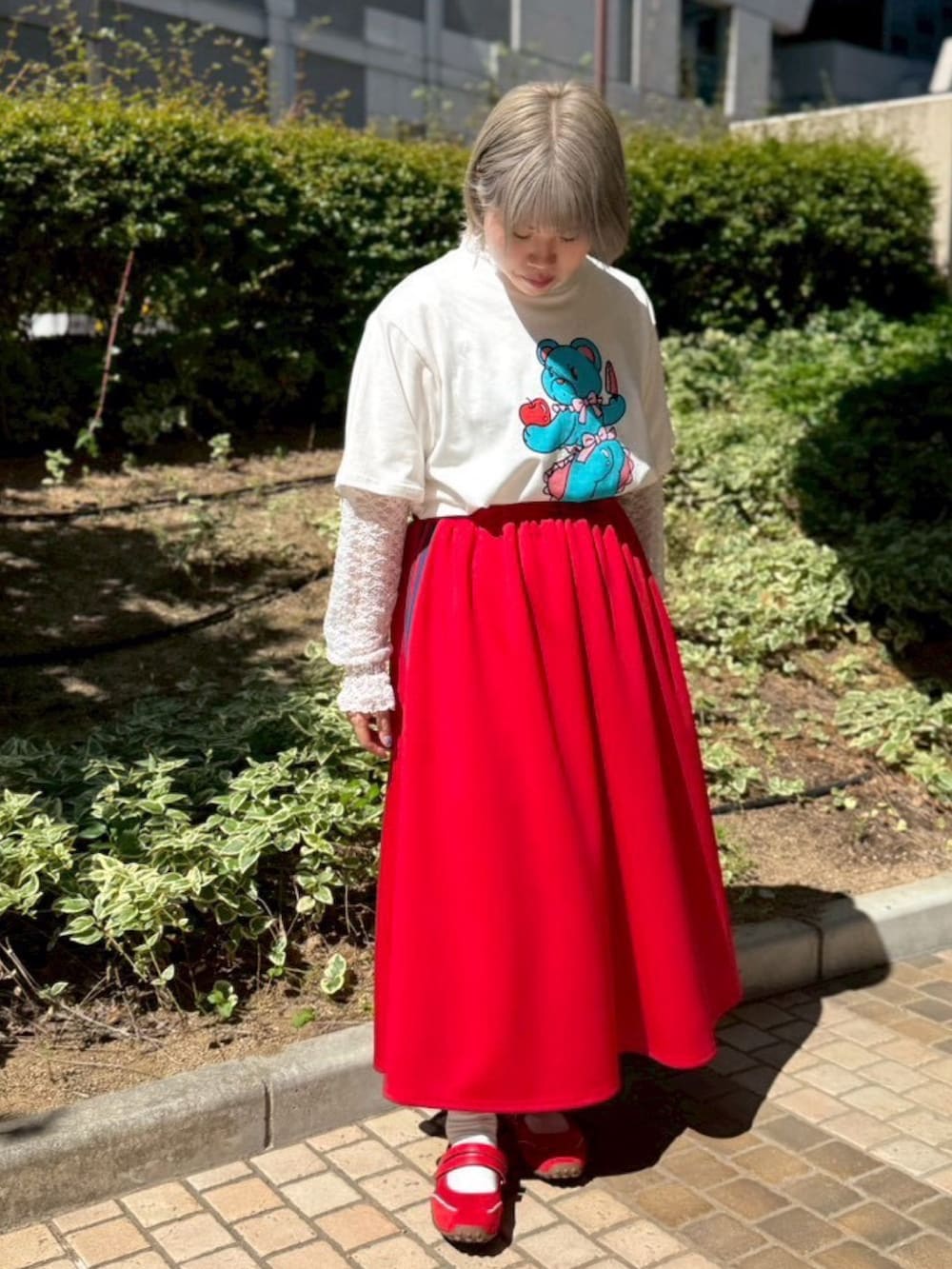 レッド系のスカート、ホワイト系のTシャツ/カットソー、ホワイト系のTシャツ/カットソーを着用したレディースの夏コーディネートの2枚目の写真