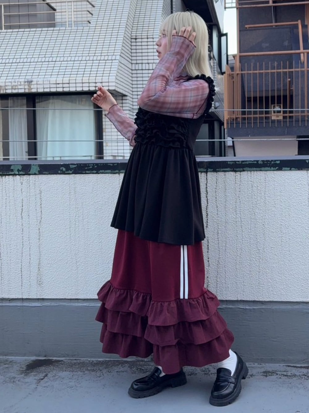 レッド系のスカート、ブラック系のワンピース、レッド系のTシャツ/カットソーを着用したレディースの秋コーディネートの3枚目の写真