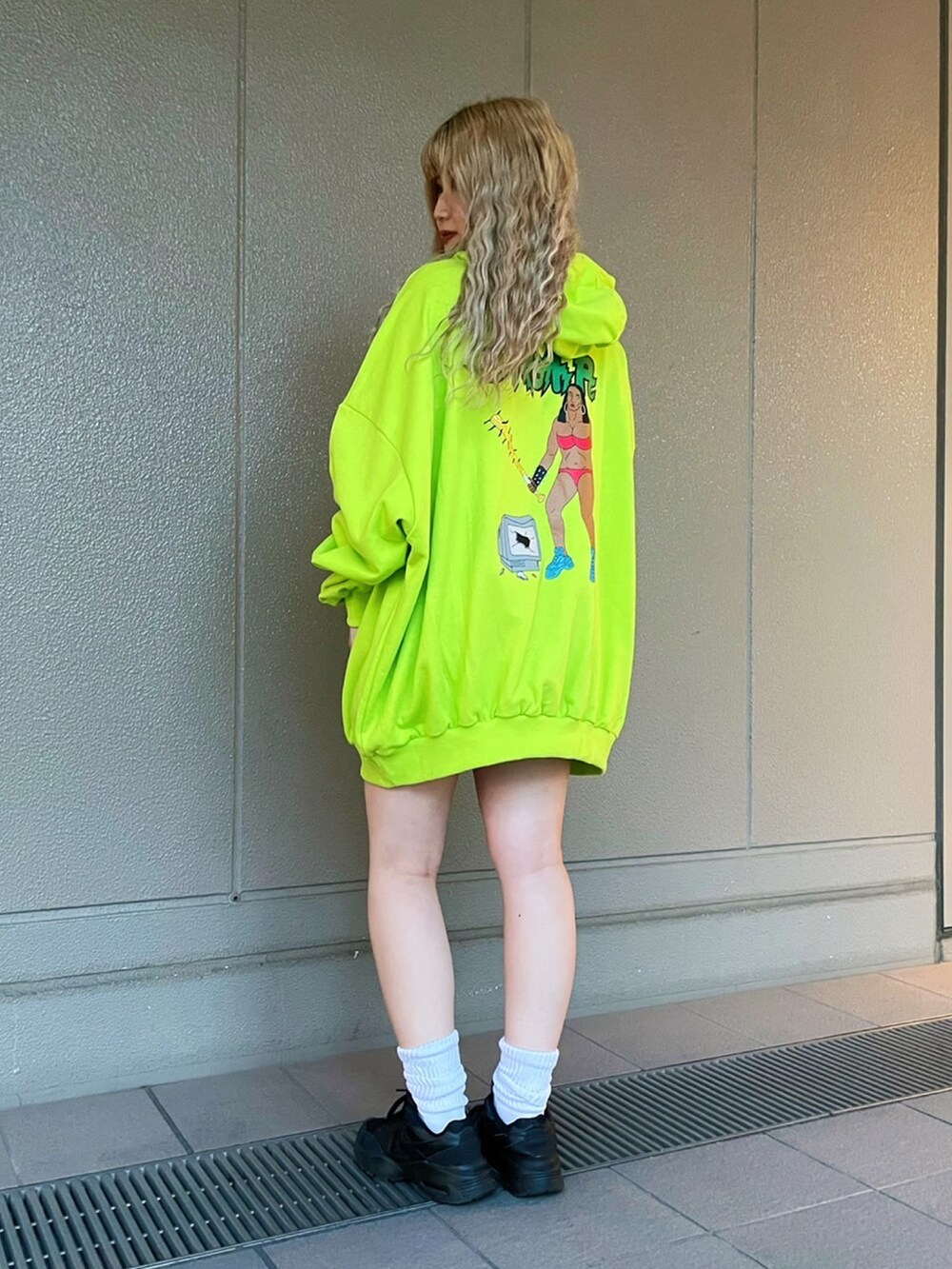 グリーン系のパーカーを着用したレディースの春コーディネートの2枚目の写真