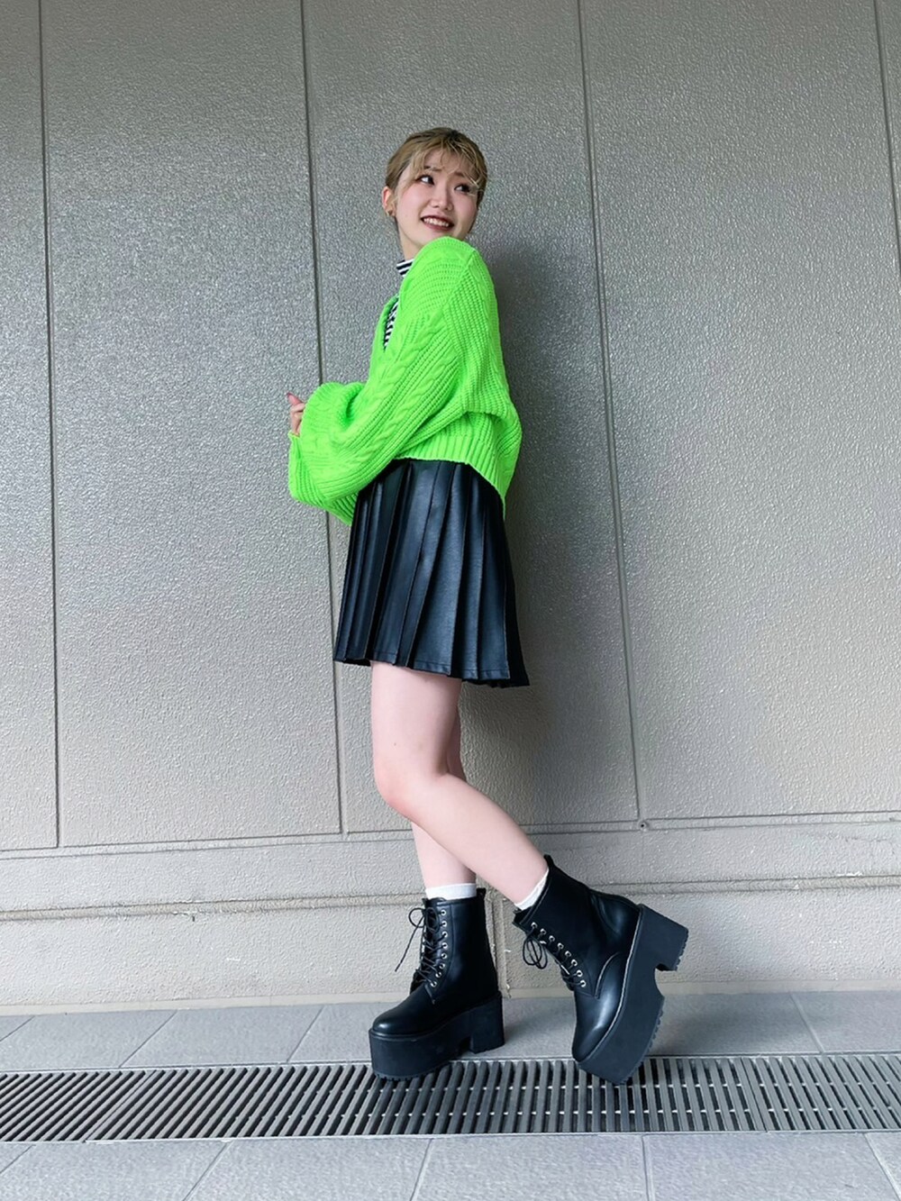 ブラック系のブーツ、ブラック系のスカート、ホワイト系のTシャツ/カットソーを着用したレディースの冬コーディネートの2枚目の写真