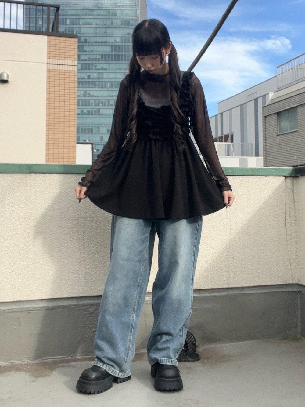 ブルー系のデニムパンツ、ブラック系のワンピース、ブラック系のTシャツ/カットソーを着用したレディースの秋コーディネートの2枚目の写真