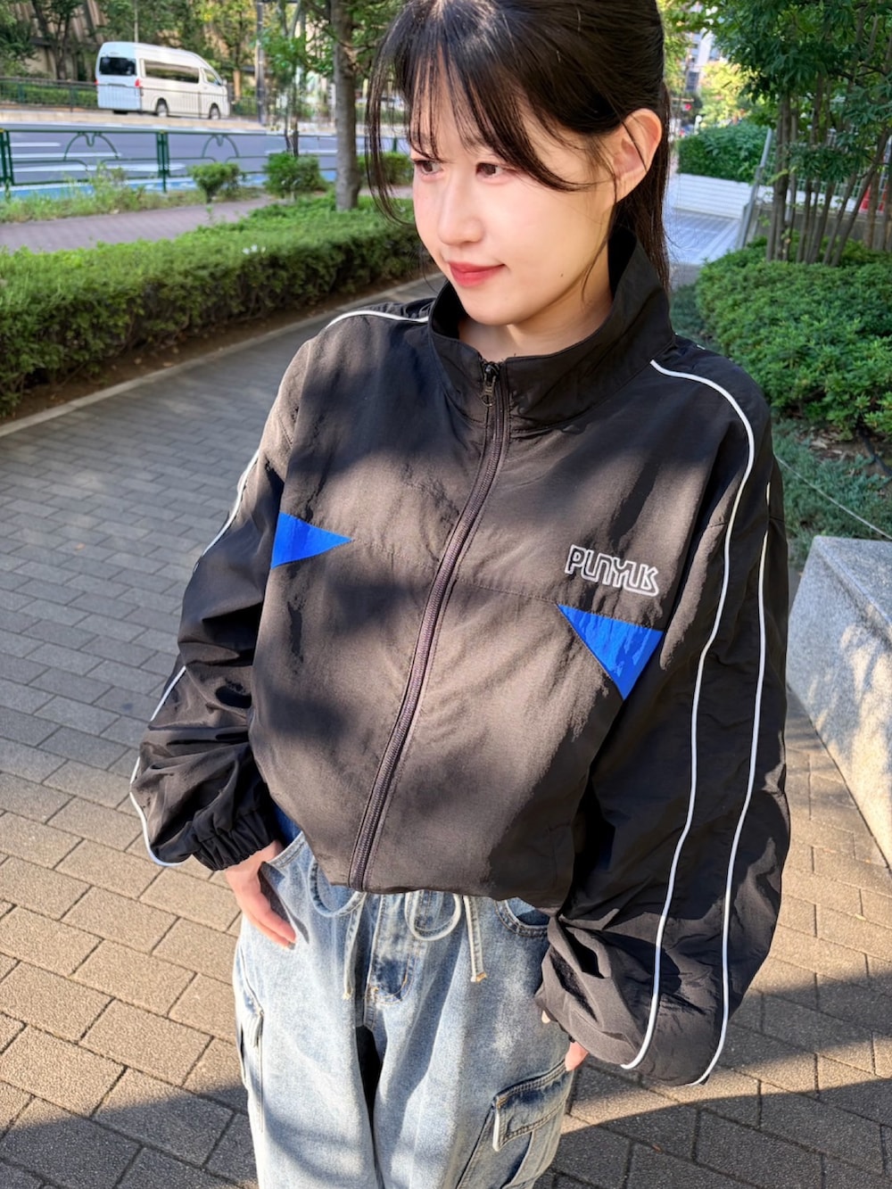 ブルー系のデニムパンツ、ブラック系のナイロンジャケットを着用したレディースの秋コーディネートの5枚目の写真