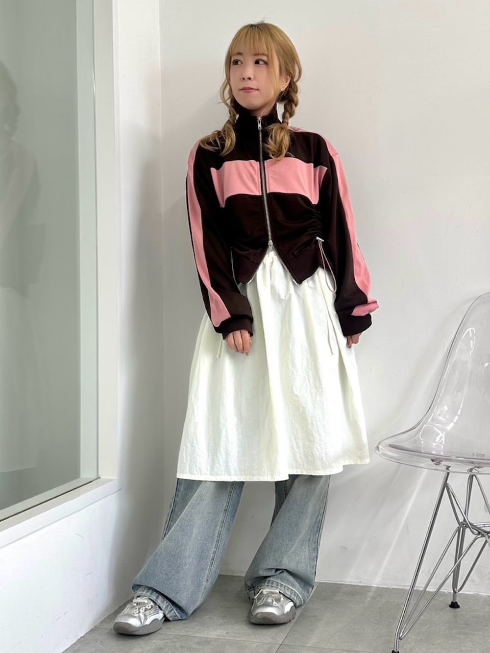 ホワイト系のワンピース、ブラウン系のジャージ、ブルー系のデニムパンツを着用したレディースの秋コーディネートの2枚目の写真