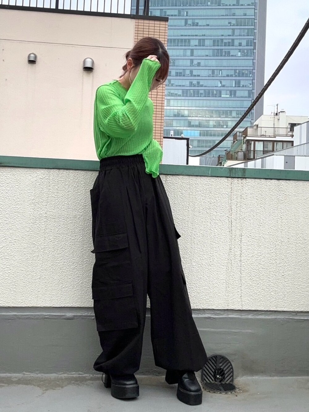 グリーン系のTシャツ/カットソー、ブラック系のカーゴパンツを着用したレディースの春コーディネートの4枚目の写真