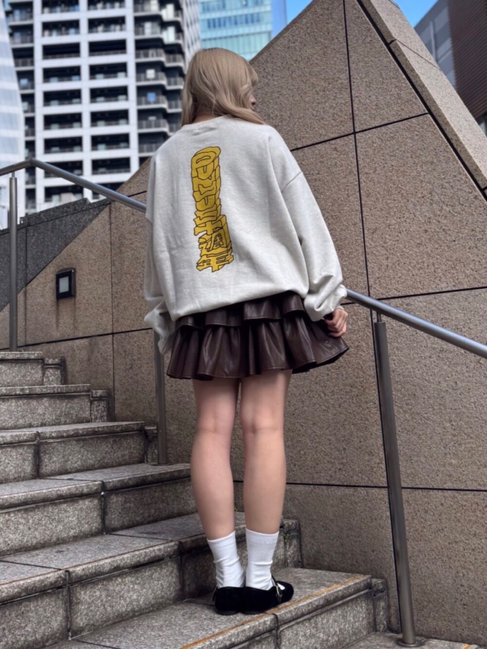 ベージュ系のスウェット、ブラウン系のスカートを着用したレディースの冬コーディネートの2枚目の写真