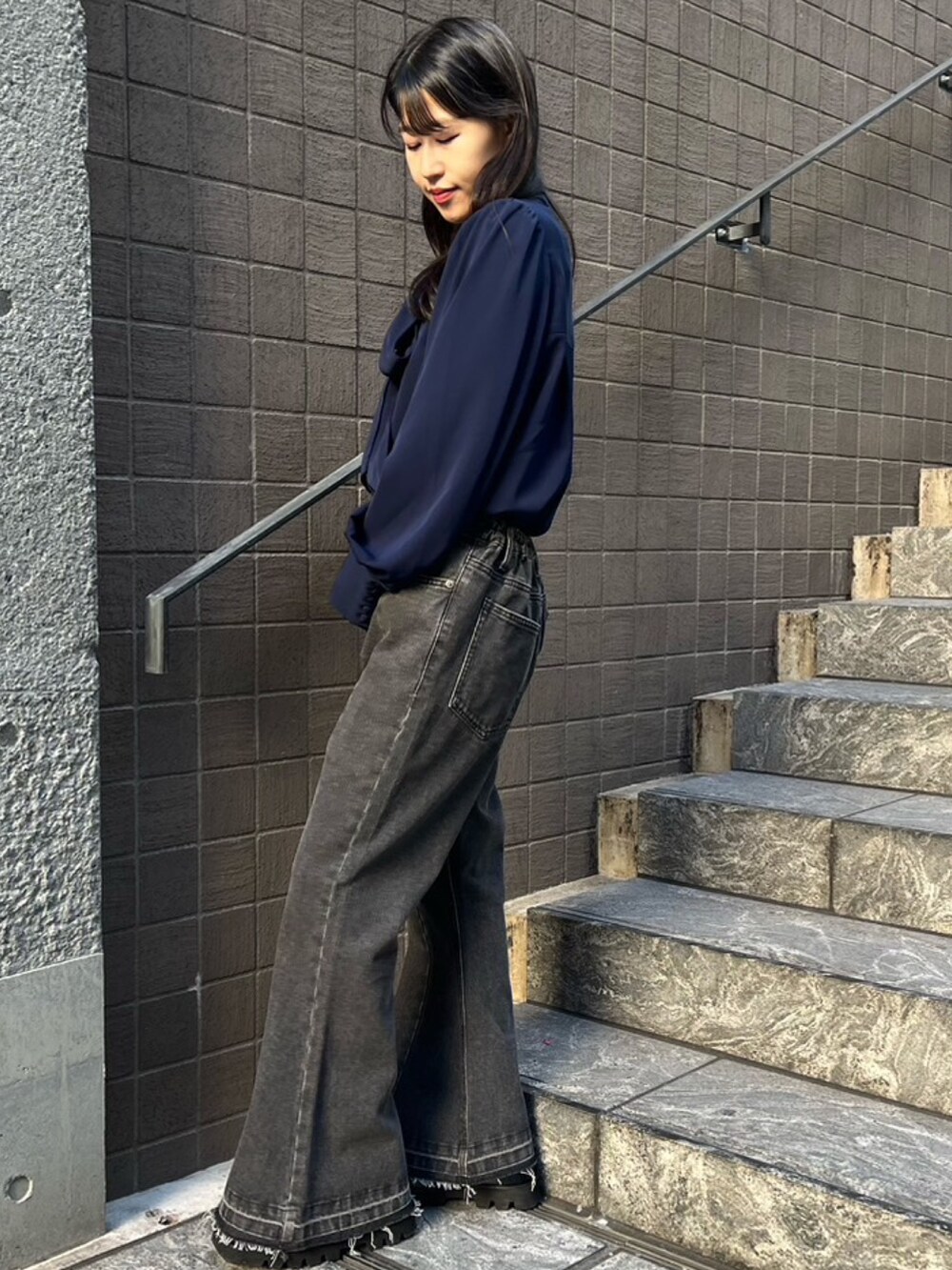 ブラック系のデニムパンツ、ブルー系のシャツ/ブラウスを着用したレディースの秋コーディネートの2枚目の写真