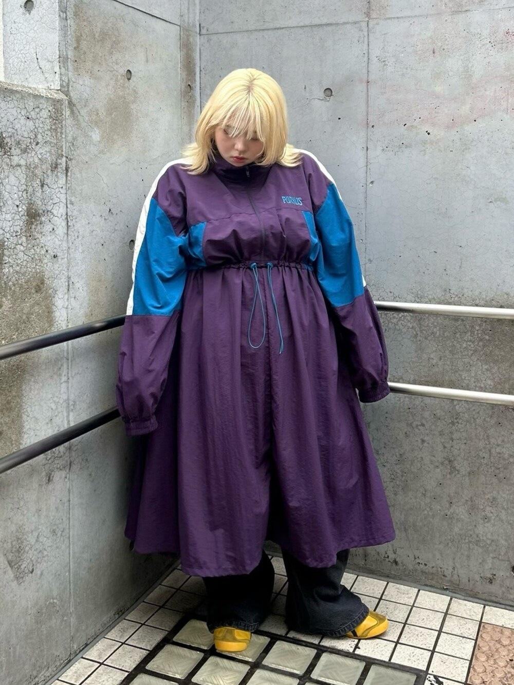 パープル系のワンピース、ブルー系のその他パンツを着用したレディースの秋コーディネートの3枚目の写真
