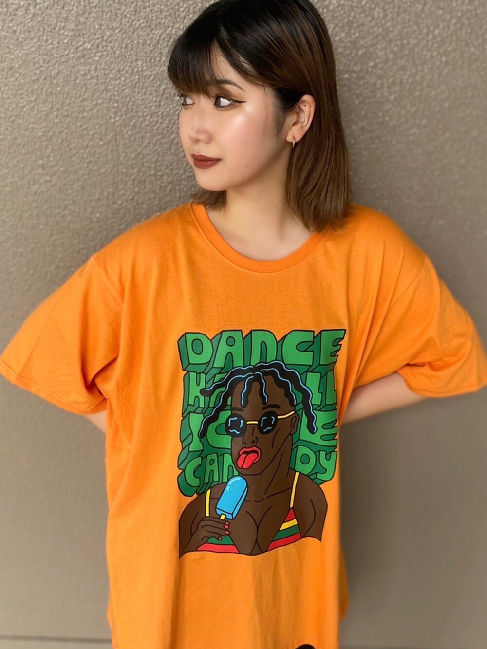 オレンジ系のTシャツ/カットソー、ブラック系のその他パンツを着用したレディースの夏コーディネートの2枚目の写真