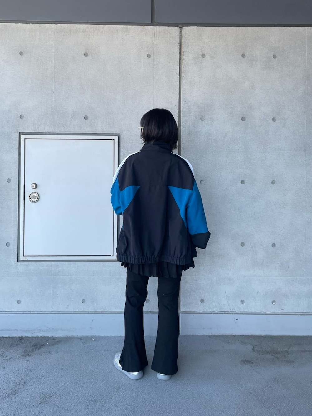 ブラック系のその他パンツ、ブラック系のナイロンジャケット、ホワイト系のTシャツ/カットソーを着用したレディースの春コーディネートの4枚目の写真
