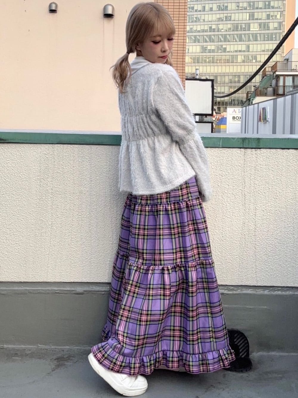 パープル系のスカート、グレー系のカーディガン/ボレロを着用したレディースの秋コーディネートの2枚目の写真