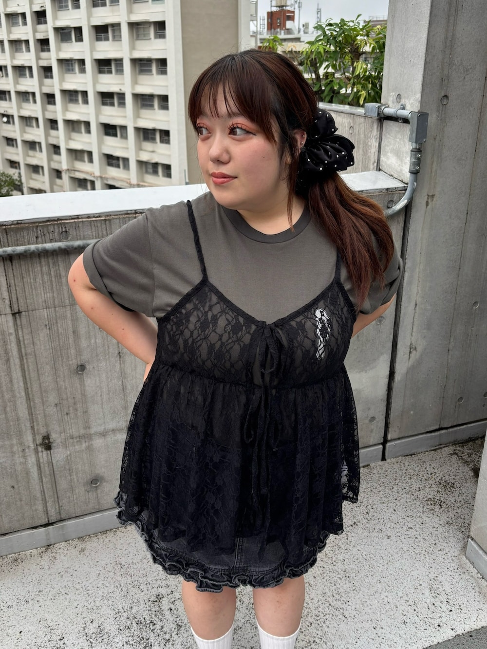 ブラック系のチュニック、ブラック系のデニムスカート、ブラック系のTシャツ/カットソーを着用したレディースの夏コーディネートの6枚目の写真