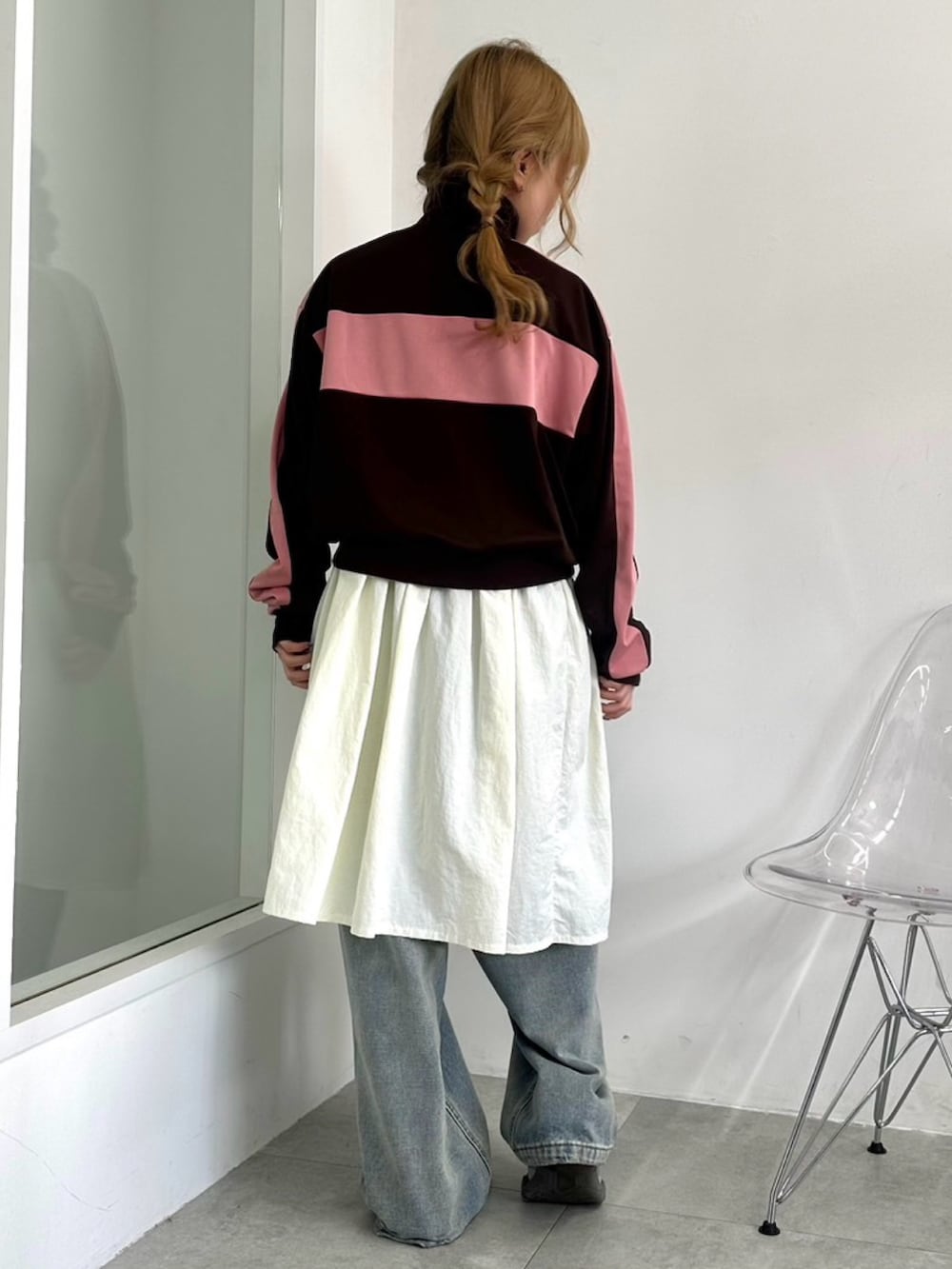 ホワイト系のワンピース、ブラウン系のジャージ、ブルー系のデニムパンツを着用したレディースの秋コーディネートの4枚目の写真