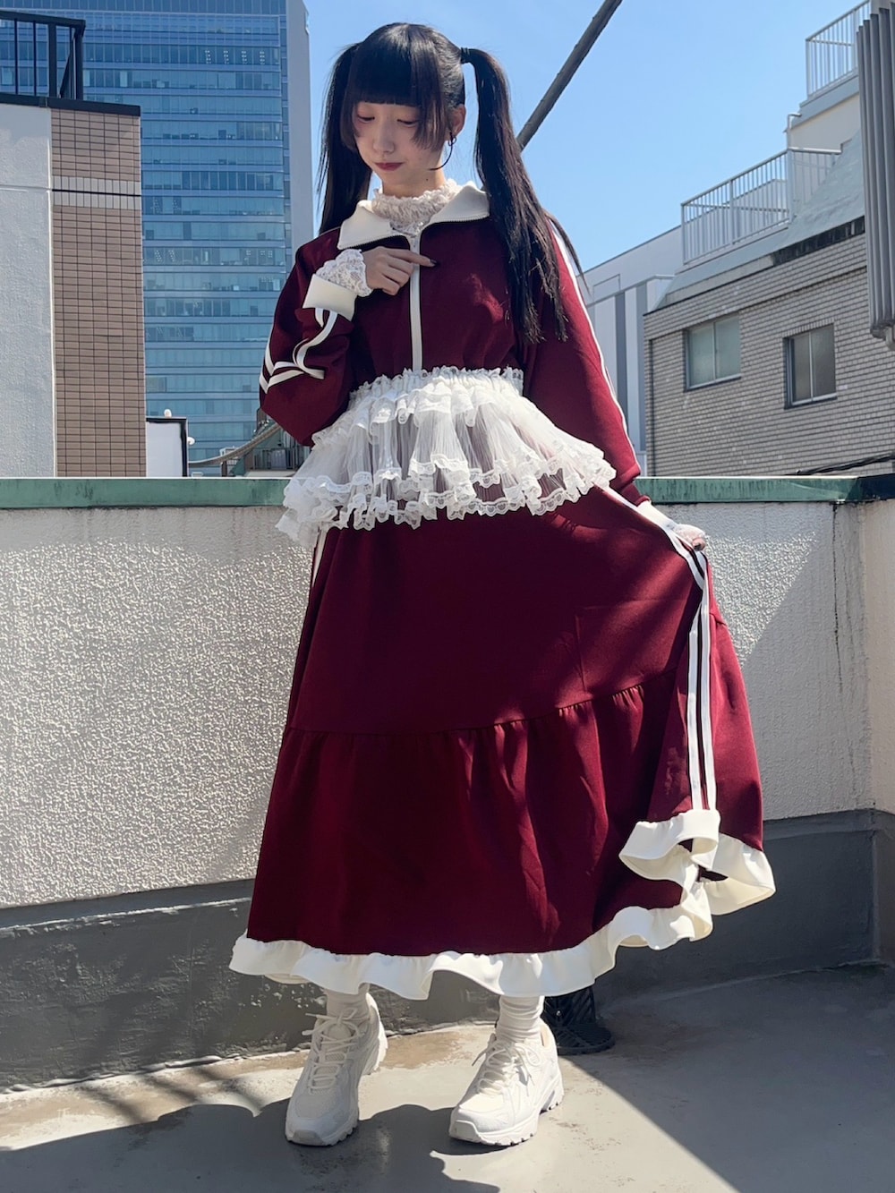 レッド系のワンピース、ホワイト系のスカート、ホワイト系のTシャツ/カットソーを着用したレディースの秋コーディネートの3枚目の写真