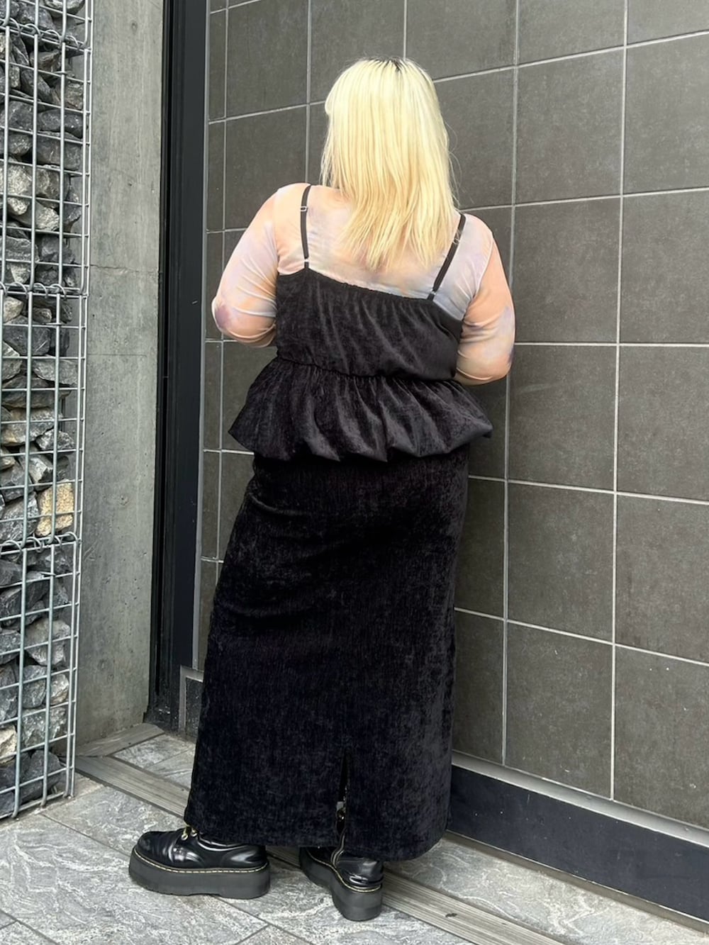 ブラック系のスカート、ブラック系のチュニック、オレンジ系のTシャツ/カットソーを着用したレディースの冬コーディネートの5枚目の写真