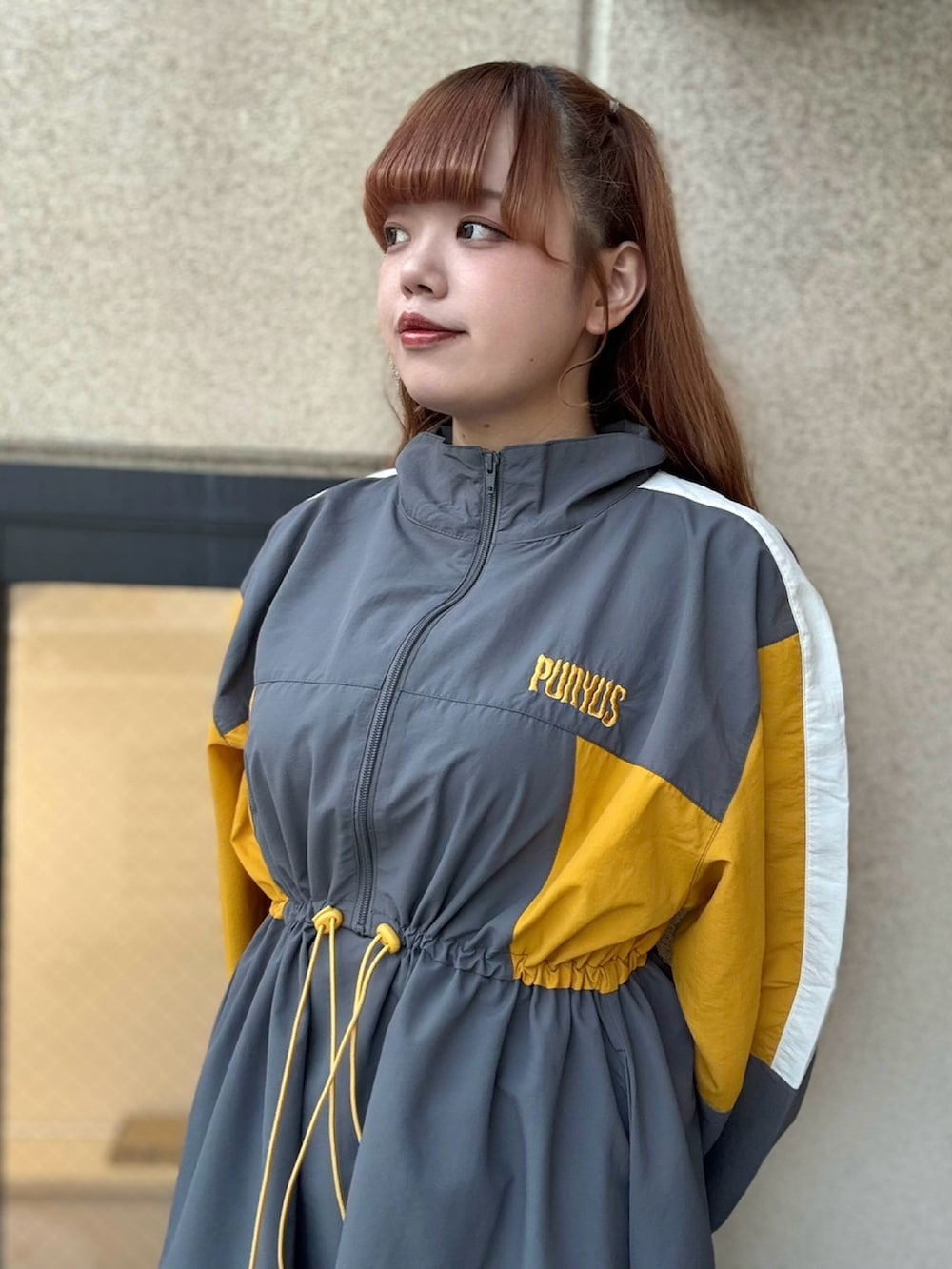 グレー系のワンピース、ブラック系のデニムパンツを着用したレディースの秋コーディネートの5枚目の写真