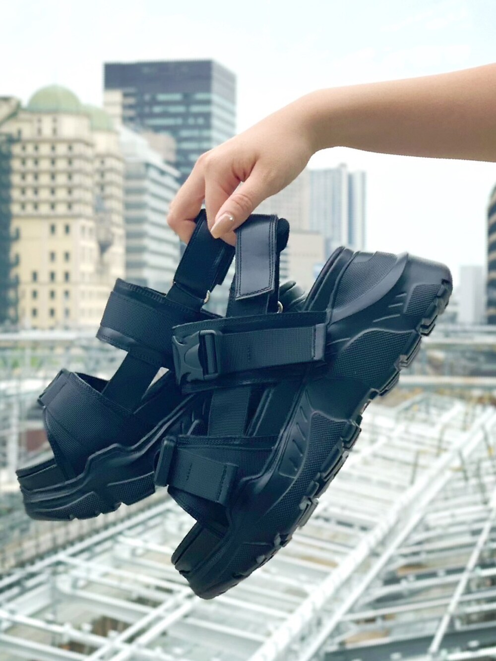 グリーン系のポロシャツ、ブルー系のデニムパンツ、ブラック系のサンダルを着用したレディースの春コーディネートの3枚目の写真